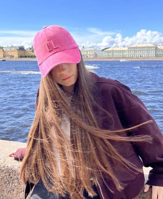 Розовая кепка LL на модели у воды
